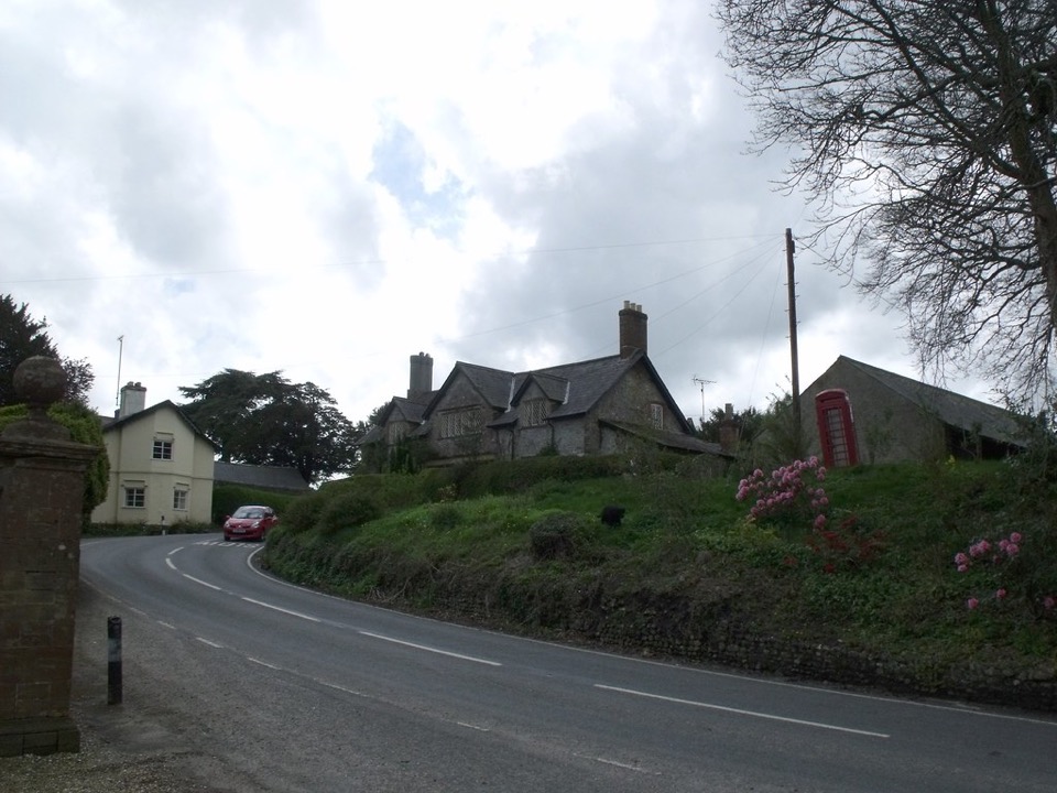 A row of stone cottages beside a red telephone box in a Dorset village